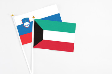 Kuwait and Slovenia stick flags on white background. High quality fabric, miniature national flag. Peaceful global concept.White floor for copy space.