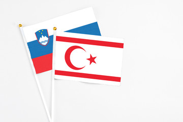 Northern Cyprus and Slovenia stick flags on white background. High quality fabric, miniature national flag. Peaceful global concept.White floor for copy space.