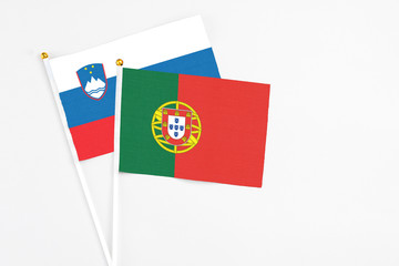 Portugal and Slovenia stick flags on white background. High quality fabric, miniature national flag. Peaceful global concept.White floor for copy space.