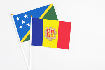 Andorra and Solomon Islands stick flags on white background. High quality fabric, miniature national flag. Peaceful global concept.White floor for copy space.