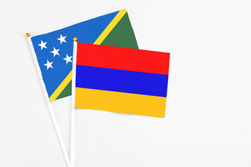 Armenia and Solomon Islands stick flags on white background. High quality fabric, miniature national flag. Peaceful global concept.White floor for copy space.
