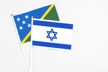 Israel and Solomon Islands stick flags on white background. High quality fabric, miniature national flag. Peaceful global concept.White floor for copy space.
