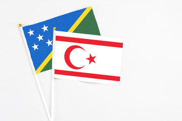Northern Cyprus and Solomon Islands stick flags on white background. High quality fabric, miniature national flag. Peaceful global concept.White floor for copy space.
