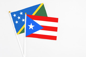Puerto Rico and Solomon Islands stick flags on white background. High quality fabric, miniature national flag. Peaceful global concept.White floor for copy space.