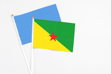 French Guiana and Somalia stick flags on white background. High quality fabric, miniature national flag. Peaceful global concept.White floor for copy space.