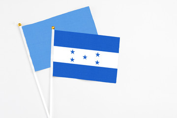 Honduras and Somalia stick flags on white background. High quality fabric, miniature national flag. Peaceful global concept.White floor for copy space.