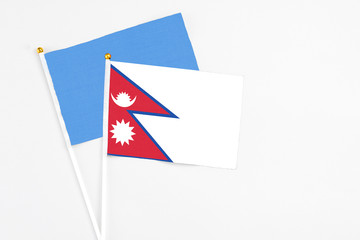 Nepal and Somalia stick flags on white background. High quality fabric, miniature national flag. Peaceful global concept.White floor for copy space.