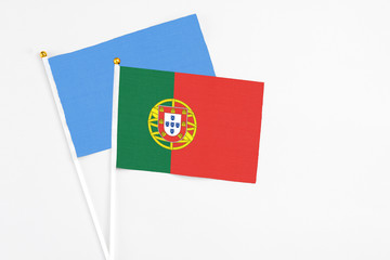 Portugal and Somalia stick flags on white background. High quality fabric, miniature national flag. Peaceful global concept.White floor for copy space.