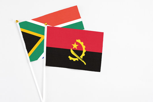 Angola and South Africa stick flags on white background. High quality fabric, miniature national flag. Peaceful global concept.White floor for copy space.