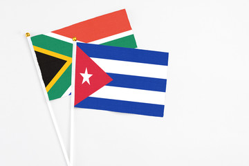 Cuba and South Africa stick flags on white background. High quality fabric, miniature national flag. Peaceful global concept.White floor for copy space.