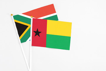 Guinea Bissau and South Africa stick flags on white background. High quality fabric, miniature national flag. Peaceful global concept.White floor for copy space.