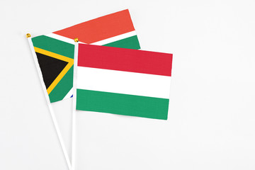 Hungary and South Africa stick flags on white background. High quality fabric, miniature national flag. Peaceful global concept.White floor for copy space.