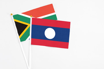 Laos and South Africa stick flags on white background. High quality fabric, miniature national flag. Peaceful global concept.White floor for copy space.