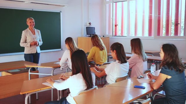 Female speaker giving lesson for university students in lecture hall 