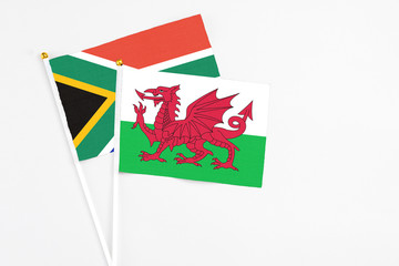 Wales and South Africa stick flags on white background. High quality fabric, miniature national flag. Peaceful global concept.White floor for copy space.