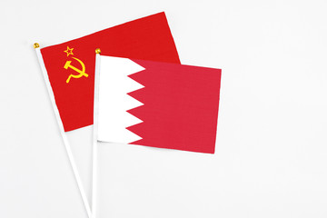 Bahrain and Soviet Union stick flags on white background. High quality fabric, miniature national flag. Peaceful global concept.White floor for copy space.
