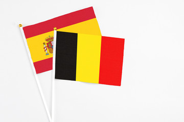 Belgium and Spain stick flags on white background. High quality fabric, miniature national flag. Peaceful global concept.White floor for copy space.