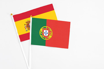 Portugal and Spain stick flags on white background. High quality fabric, miniature national flag. Peaceful global concept.White floor for copy space.