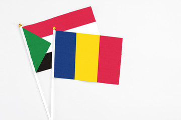 Chad and Sudan stick flags on white background. High quality fabric, miniature national flag. Peaceful global concept.White floor for copy space.