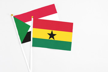 Ghana and Sudan stick flags on white background. High quality fabric, miniature national flag. Peaceful global concept.White floor for copy space.
