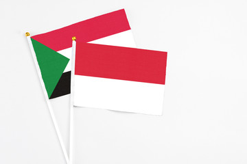 Indonesia and Sudan stick flags on white background. High quality fabric, miniature national flag. Peaceful global concept.White floor for copy space.
