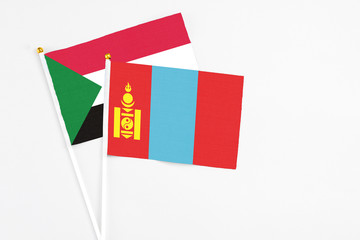 Mongolia and Sudan stick flags on white background. High quality fabric, miniature national flag. Peaceful global concept.White floor for copy space.