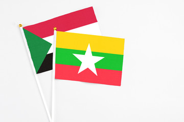 Myanmar and Sudan stick flags on white background. High quality fabric, miniature national flag. Peaceful global concept.White floor for copy space.