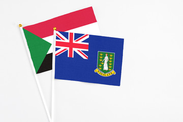 Fototapeta premium British Virgin Islands and Sudan stick flags on white background. High quality fabric, miniature national flag. Peaceful global concept.White floor for copy space.