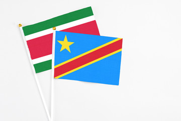 Congo and Suriname stick flags on white background. High quality fabric, miniature national flag. Peaceful global concept.White floor for copy space.