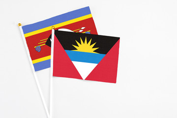 Antigua and Barbuda and Swaziland stick flags on white background. High quality fabric, miniature national flag. Peaceful global concept.White floor for copy space.