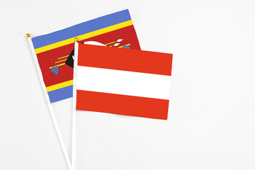 Austria and Swaziland stick flags on white background. High quality fabric, miniature national flag. Peaceful global concept.White floor for copy space.