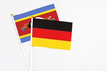 Germany and Swaziland stick flags on white background. High quality fabric, miniature national flag. Peaceful global concept.White floor for copy space.