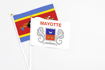 Mayotte and Swaziland stick flags on white background. High quality fabric, miniature national flag. Peaceful global concept.White floor for copy space.