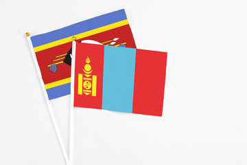 Fototapeta premium Mongolia and Swaziland stick flags on white background. High quality fabric, miniature national flag. Peaceful global concept.White floor for copy space.