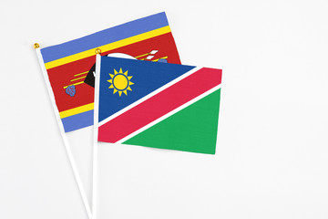 Namibia and Swaziland stick flags on white background. High quality fabric, miniature national flag. Peaceful global concept.White floor for copy space.