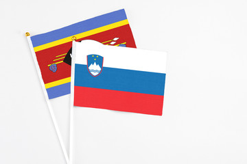Slovenia and Swaziland stick flags on white background. High quality fabric, miniature national flag. Peaceful global concept.White floor for copy space.