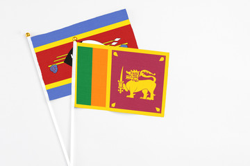 Sri Lanka and Swaziland stick flags on white background. High quality fabric, miniature national flag. Peaceful global concept.White floor for copy space.