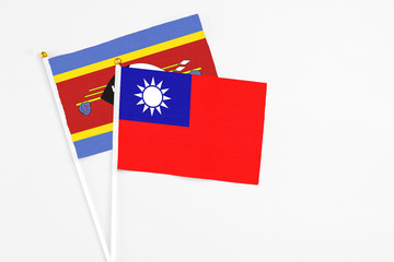 Taiwan and Swaziland stick flags on white background. High quality fabric, miniature national flag. Peaceful global concept.White floor for copy space.