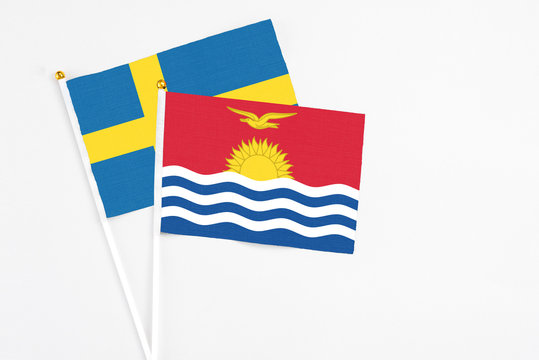 Kiribati and Sweden stick flags on white background. High quality fabric, miniature national flag. Peaceful global concept.White floor for copy space.