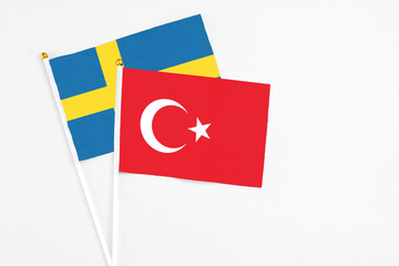 Turkey and Sweden stick flags on white background. High quality fabric, miniature national flag. Peaceful global concept.White floor for copy space.