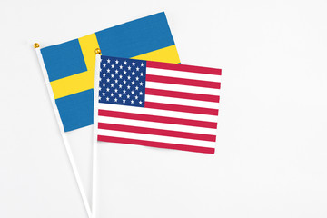 United States and Sweden stick flags on white background. High quality fabric, miniature national flag. Peaceful global concept.White floor for copy space.