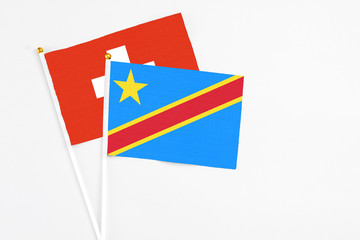 Congo and Switzerland stick flags on white background. High quality fabric, miniature national flag. Peaceful global concept.White floor for copy space.