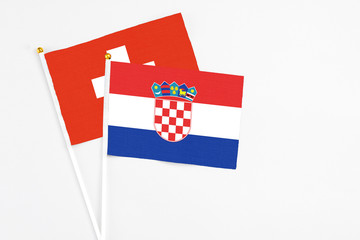 Croatia and Switzerland stick flags on white background. High quality fabric, miniature national flag. Peaceful global concept.White floor for copy space.