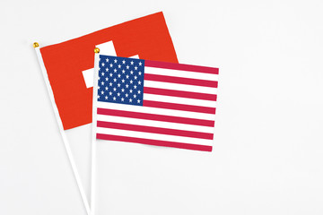 United States and Switzerland stick flags on white background. High quality fabric, miniature national flag. Peaceful global concept.White floor for copy space.