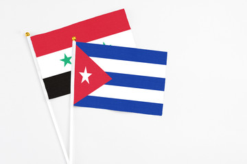 Cuba and Syria stick flags on white background. High quality fabric, miniature national flag. Peaceful global concept.White floor for copy space.
