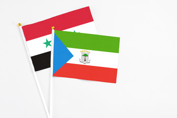 Equatorial Guinea and Syria stick flags on white background. High quality fabric, miniature national flag. Peaceful global concept.White floor for copy space.