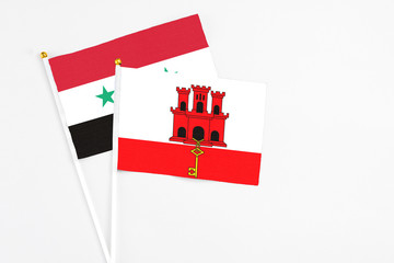 Gibraltar and Syria stick flags on white background. High quality fabric, miniature national flag....