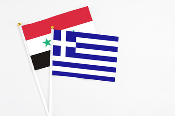 Greece and Syria stick flags on white background. High quality fabric, miniature national flag. Peaceful global concept.White floor for copy space.