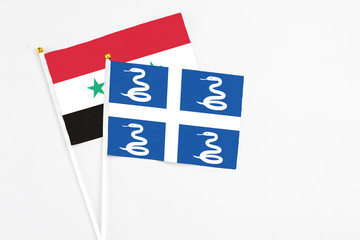 Martinique and Syria stick flags on white background. High quality fabric, miniature national flag. Peaceful global concept.White floor for copy space.