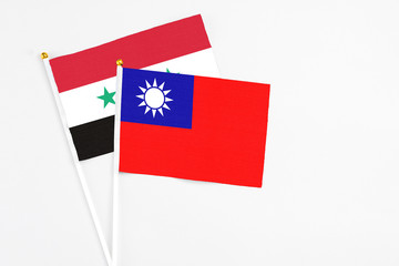 Taiwan and Syria stick flags on white background. High quality fabric, miniature national flag. Peaceful global concept.White floor for copy space.
